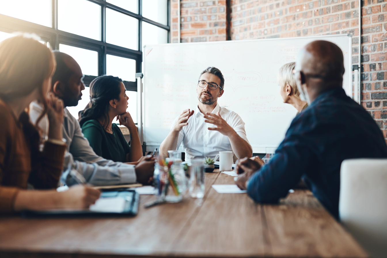 A diverse group in discussion around a boardroom table