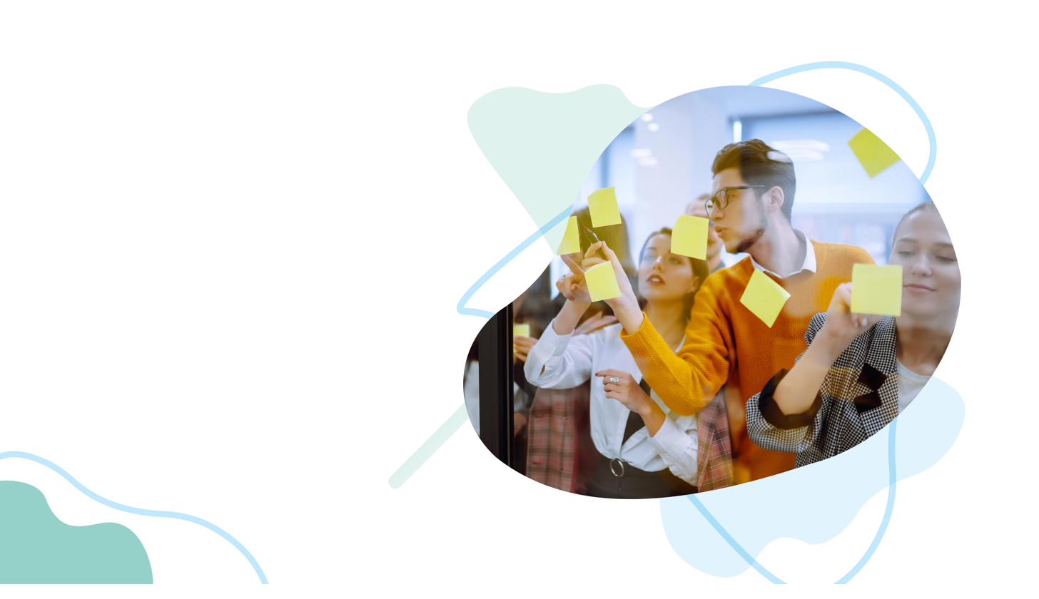 A team collaborating with sticky notes on a glass wall